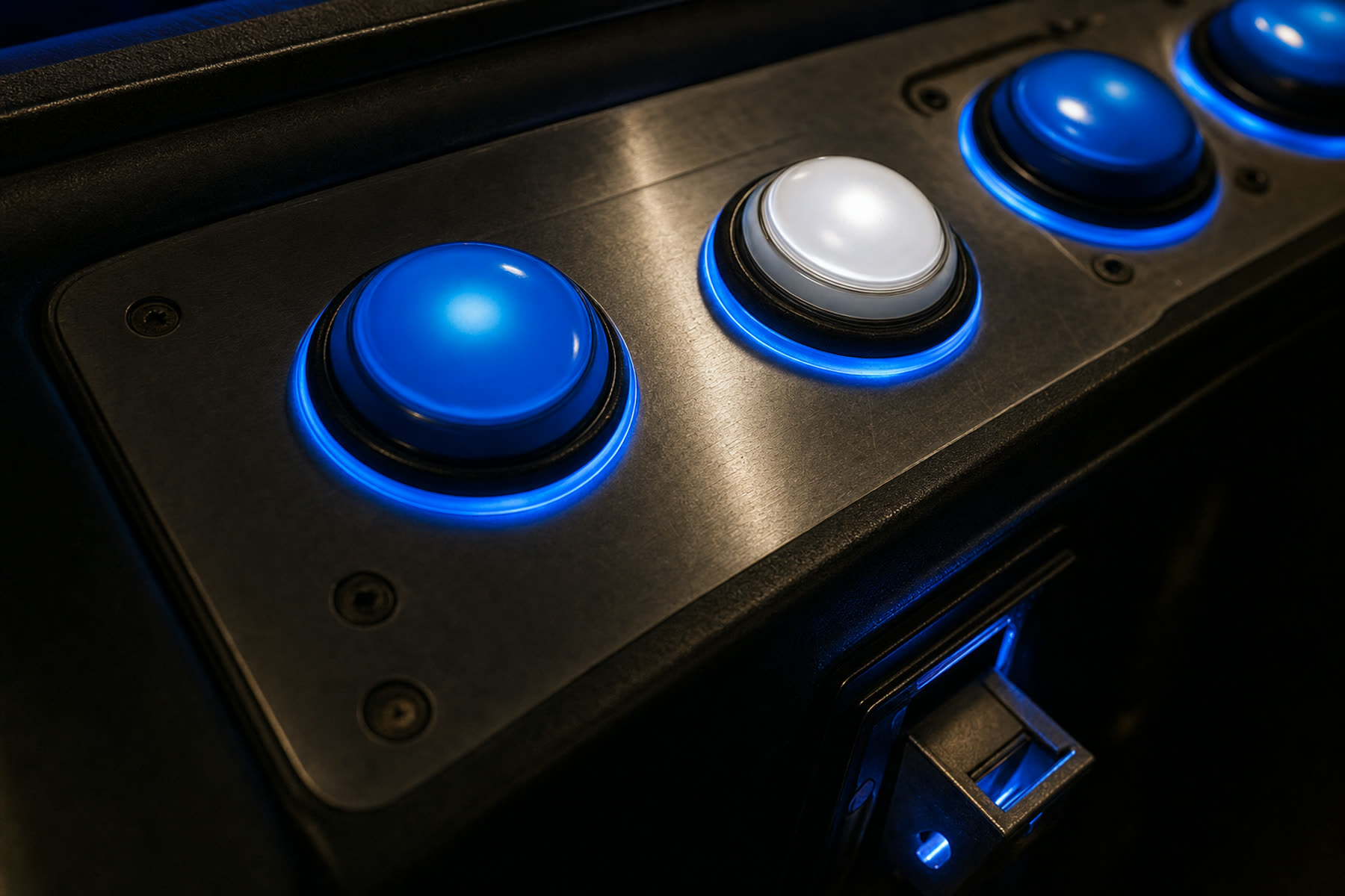 Close-up of an illuminated amusement machine control panel with blue backlit buttons.